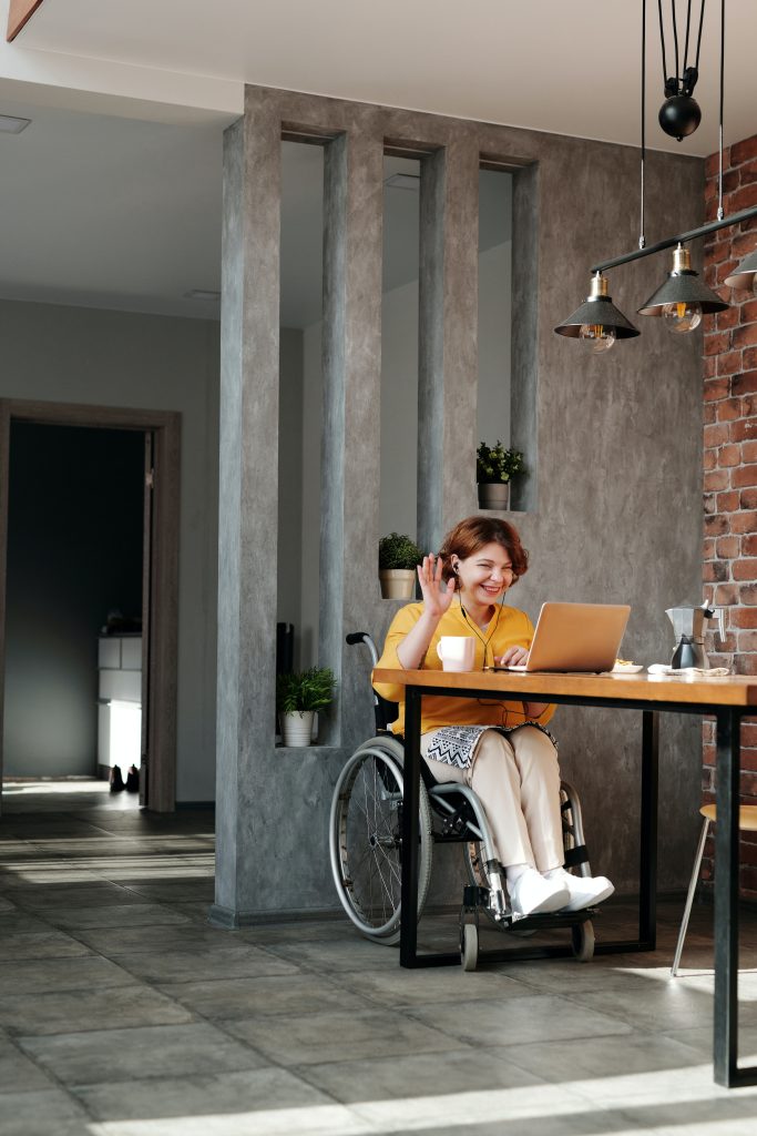 Usuario de silla de ruedas trabaja desde casa en un hogar accesible.